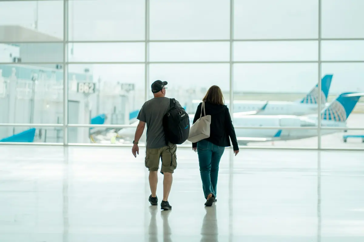 Travellers walking through an airport terminal towards their transfer