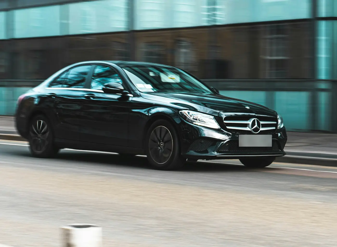 Black Mercedes-Benz saloon driving through the city